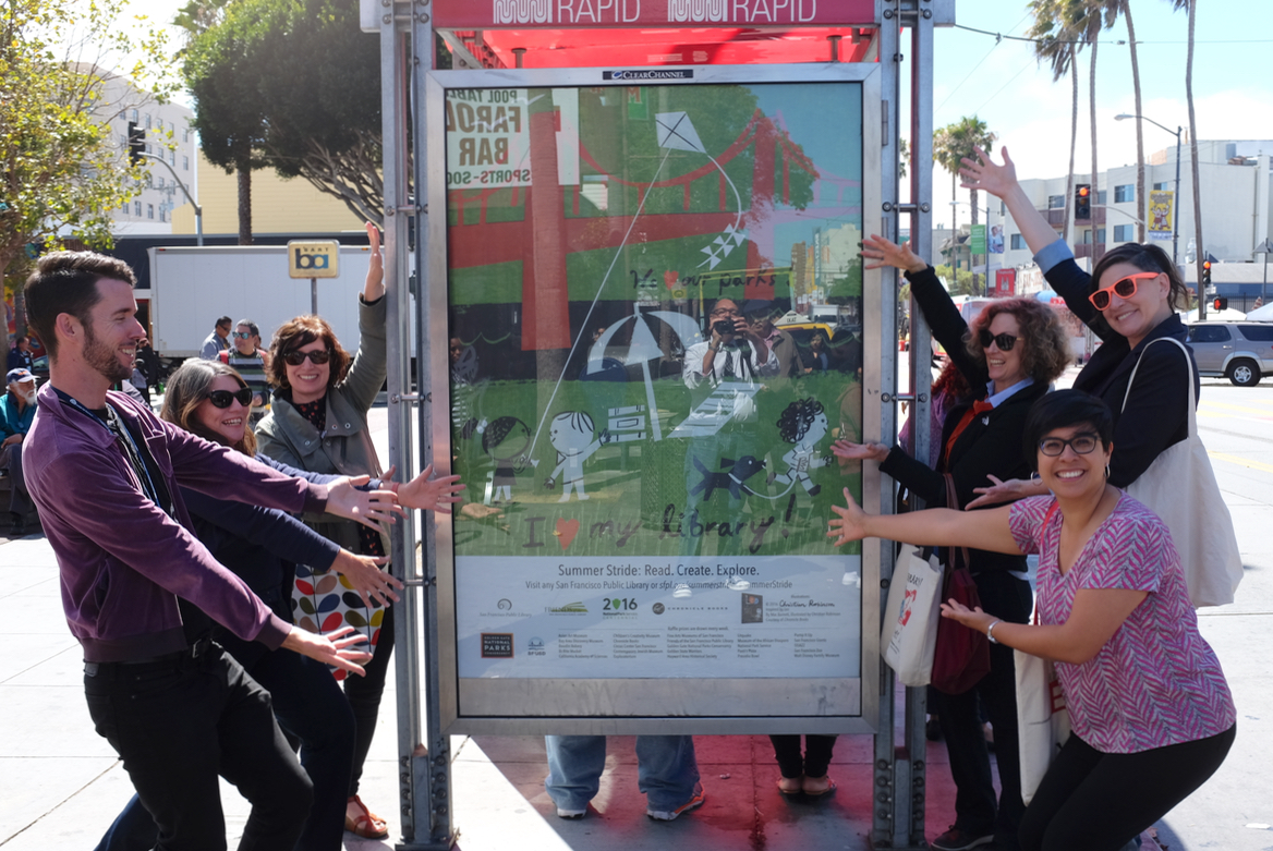 People posing in front of a Tracking Tree billboard