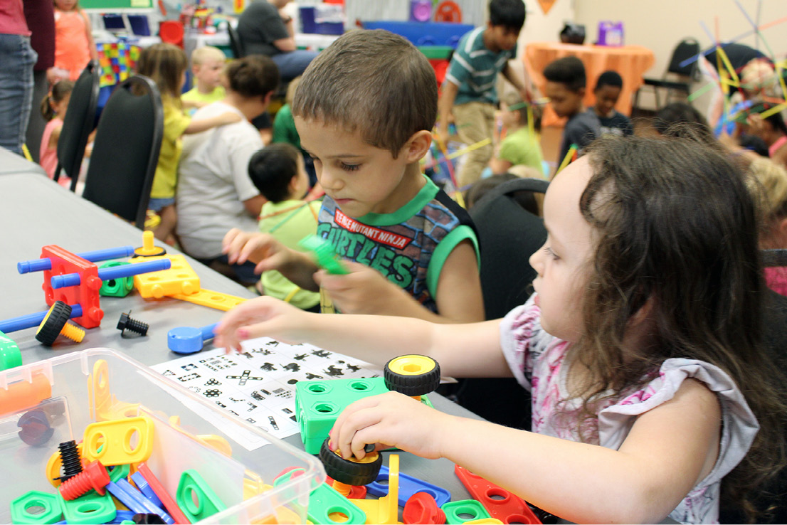 Boy and girl working together on a play construction project.