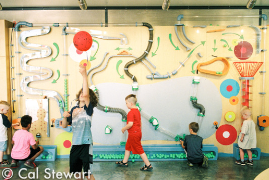 Children interact with a wall display.