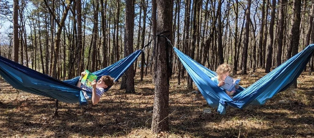 Evan McCartney, eleven, and his sister Elizabeth, seven, reading books in hammocks