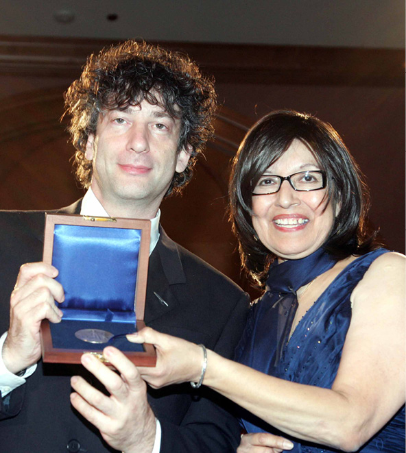 Newbery Committee Chair Rose V. Treviño presents the 2009 Newbery Medal to Neil Gaiman for The Graveyard Book.