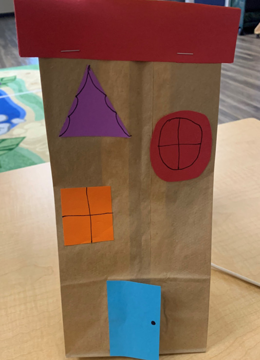 An example of a house that was made with a paper bag and construction paper for a STEAM storytime.
