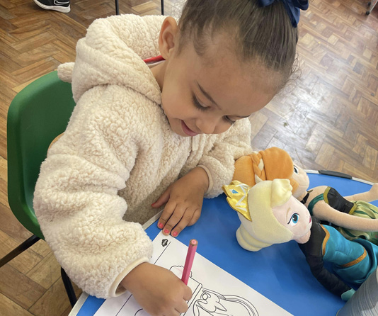 A preschooler coloring in a coloring book.