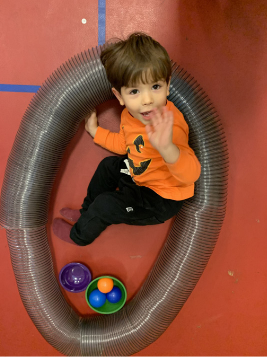 “Mom, look at these!” An excited child uses giant slinky tubes to make a nest during Anji Playdate.