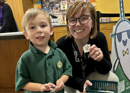 Tulsa City-County Library Children's Associate Angela Martinez gives a sticker to her storytime regular Ryker.