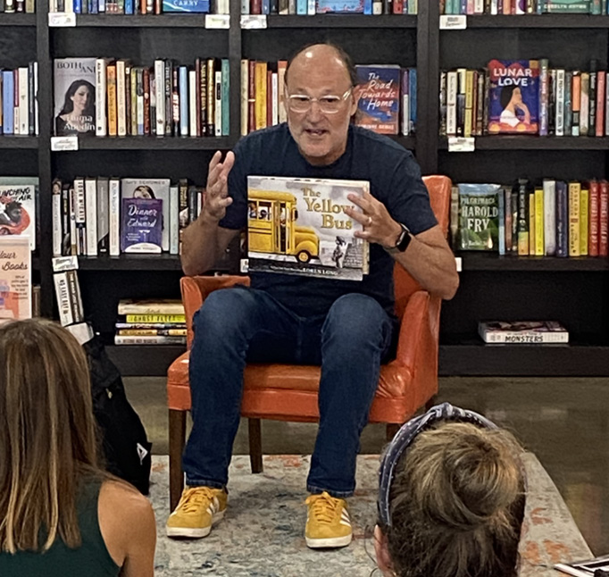 Author/illustrator Loren Long reading his new book, The Yellow Bus (Roaring Brook, 2024), during an event at The Book Bus Depot in Cincinnati, OH, last summer.