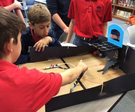 Middle school students creating a basketball game out of littleBits for the media center arcade.