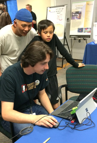 Figure 5. A library staff member works with a father and son at our inaugural Imagine IT technology fair